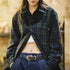 Person wearing a blue green plaid coat with a blurred background
